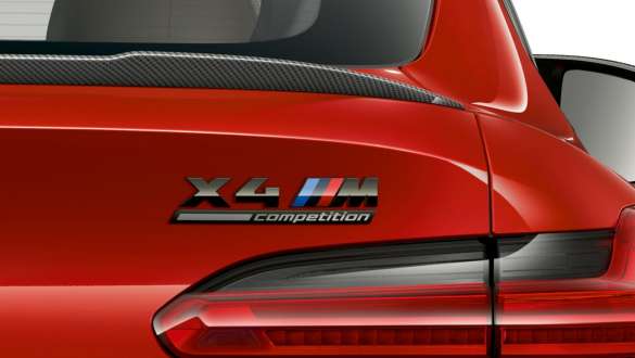 BMW X4 M Competition SUV F98, rear with “X4 M Competition” designation. BMW X4 M Competition SUV F98 in Toronto Red metallic, exterior, close-up view rear with rear spoiler in carbon and “X4 M Competition” designation.