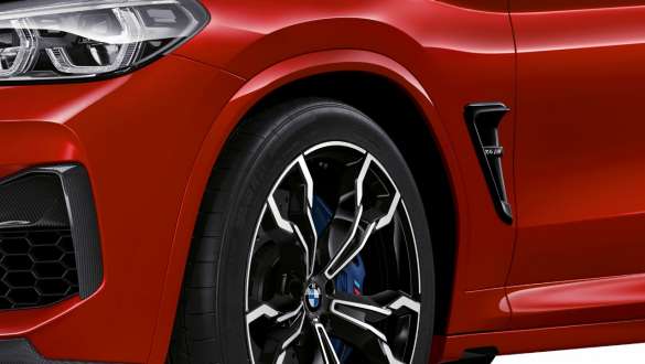 BMW X4 M Competition SUV F98, close-up view lateral rear. BMW X4 M Competition SUV F98 in Toronto Red metallic, exterior, close-up view lateral rear, M specific suspension.