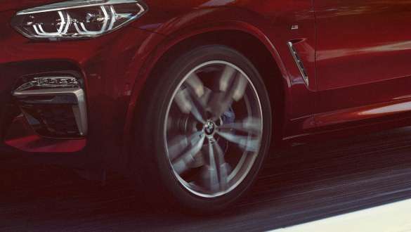 Adaptive M suspension BMW X4 Adaptive M suspension BMW X4 M40i G02 2018 Flamenco Red brilliant effect three-quarter side view with light alloy wheel