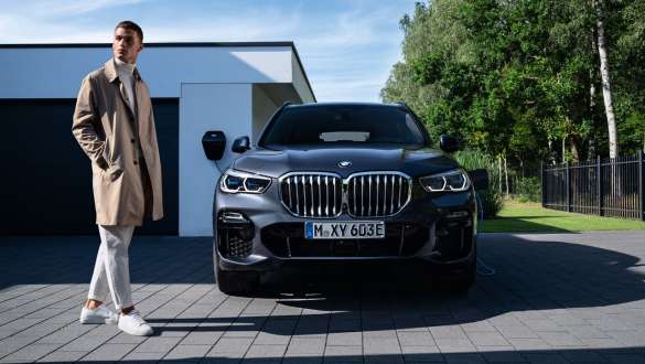 Plug-in hybrid BMW X5 xDrive45e G05 front view in front of garage Plug-in hybrid BMW X5 xDrive45e G05 front view in front of garage with model