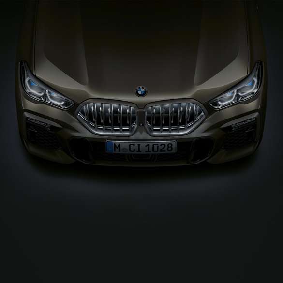 BMW X6 SUV G06 front. Close-up view of the BMW X6 SUV G06 front with BMW kidney grille ‘Iconic Glow’ from a bird's eye view.