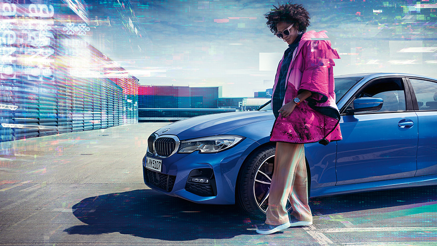 BMW 3 Series Sedan (G20), Portimao blue metallic, 7/8 front BMW 3 Series Sedan (G20), Portimao blue metallic, 7/8 front on parking deck with person in the foreground