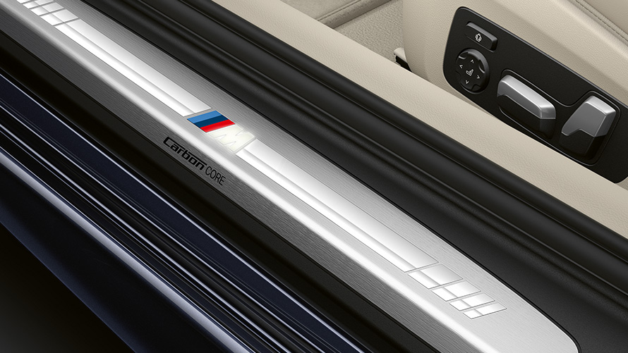 Close-up of the door sill of the BMW 8 Series Coupé with M logo.