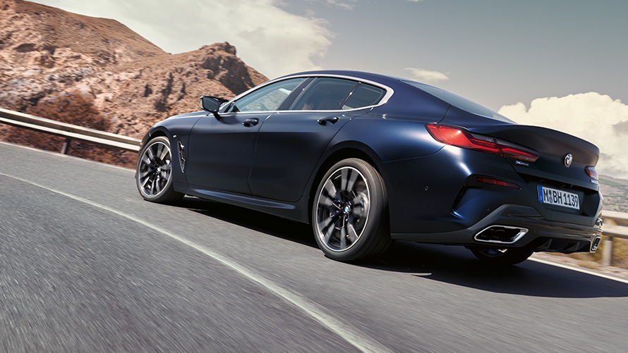 BMW 840i xDrive Gran Coupé G16 LCI Facelift 2022 driving on a mountain road BMW 840i xDrive Gran Coupé G16 LCI Facelift 2022 Portimao Blue metallic three-quarter front rear driving on a mountain road