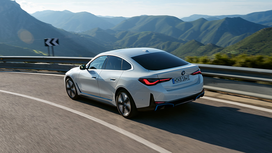Three-quarter rear view BMW i4 eDrive35 G26 2021 driving BMW i4 eDrive35 G26 2021 Mineral White three-quarter rear view driving