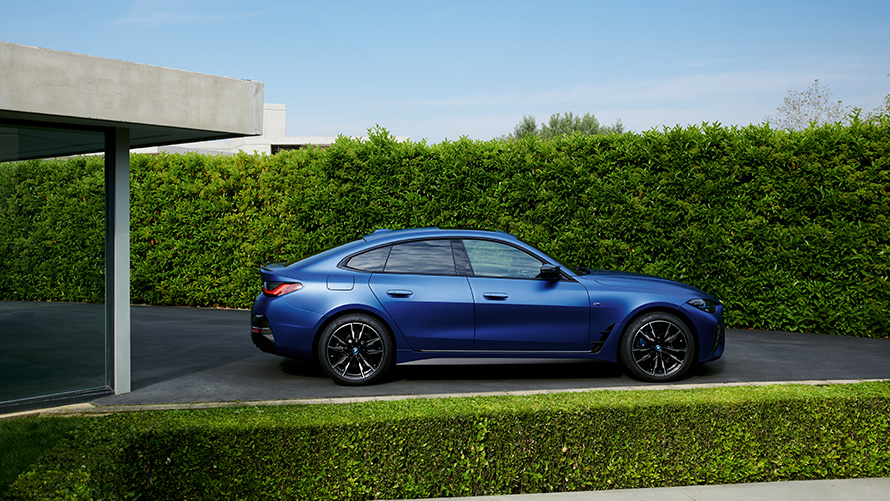 BMW i4 M50 G26 2021 BMW Individual Frozen Portimao Blue metallic rear view driving on country road