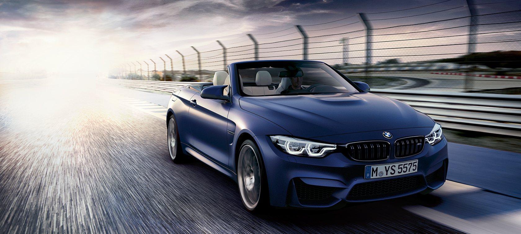 BMW M-Series M4 Convertible dark blue: fast moving car on highway BMW M-Series M4 Convertible dark blue: fast moving car on highway