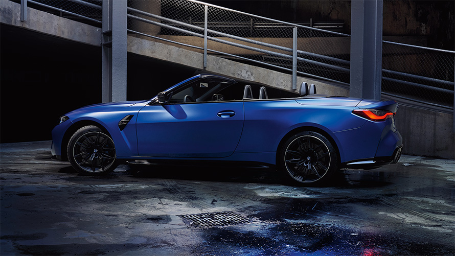 BMW M4 Competition Convertible with M xDrive G83 2021 side view with open softtop BMW M4 Competition Convertible with M xDrive G83 2021 Frozen Portimao Blue metallic side view with open softtop