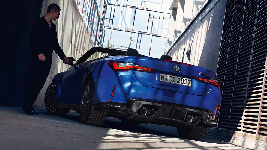 BMW M4 Competition Convertible with M xDrive G83 2021 three-quarter rear view BMW M4 Competition Convertible with M xDrive G83 2021 Frozen Portimao Blue metallic three-quarter rear view with man