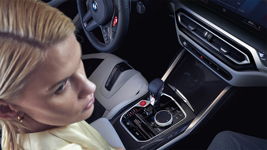 BMW M4 Competition Convertible with M xDrive G83 interior 2021 centre console BMW M4 Competition Convertible with M xDrive G83 2021 centre console and women on passenger seat