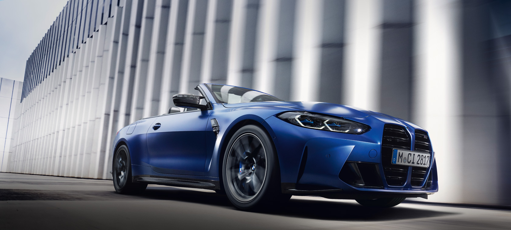 BMW M4 Competition Convertible with M xDrive G83 2021 BMW Individual Frozen Portimao Blue metallic three-quarter front view in motion