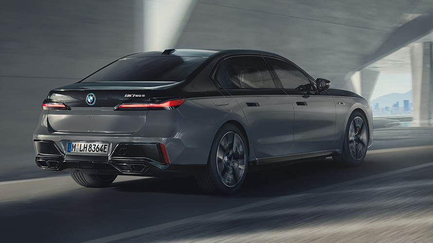 BMW M760e xDrive Sedan G70 M Performance Package BMW M760e xDrive Sedan G70 M Performance Package BMW Individual two-tone Black Sapphire metallic paintwork BMW Individual Dravite Grey metallic three-quarter rear view driving on the street