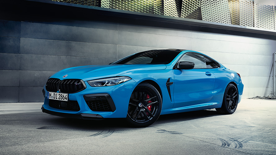 BMW M8 F92 three-quarter rear view standing with model BMW M Series BMW M8 F92 three-quarter rear view standing with model