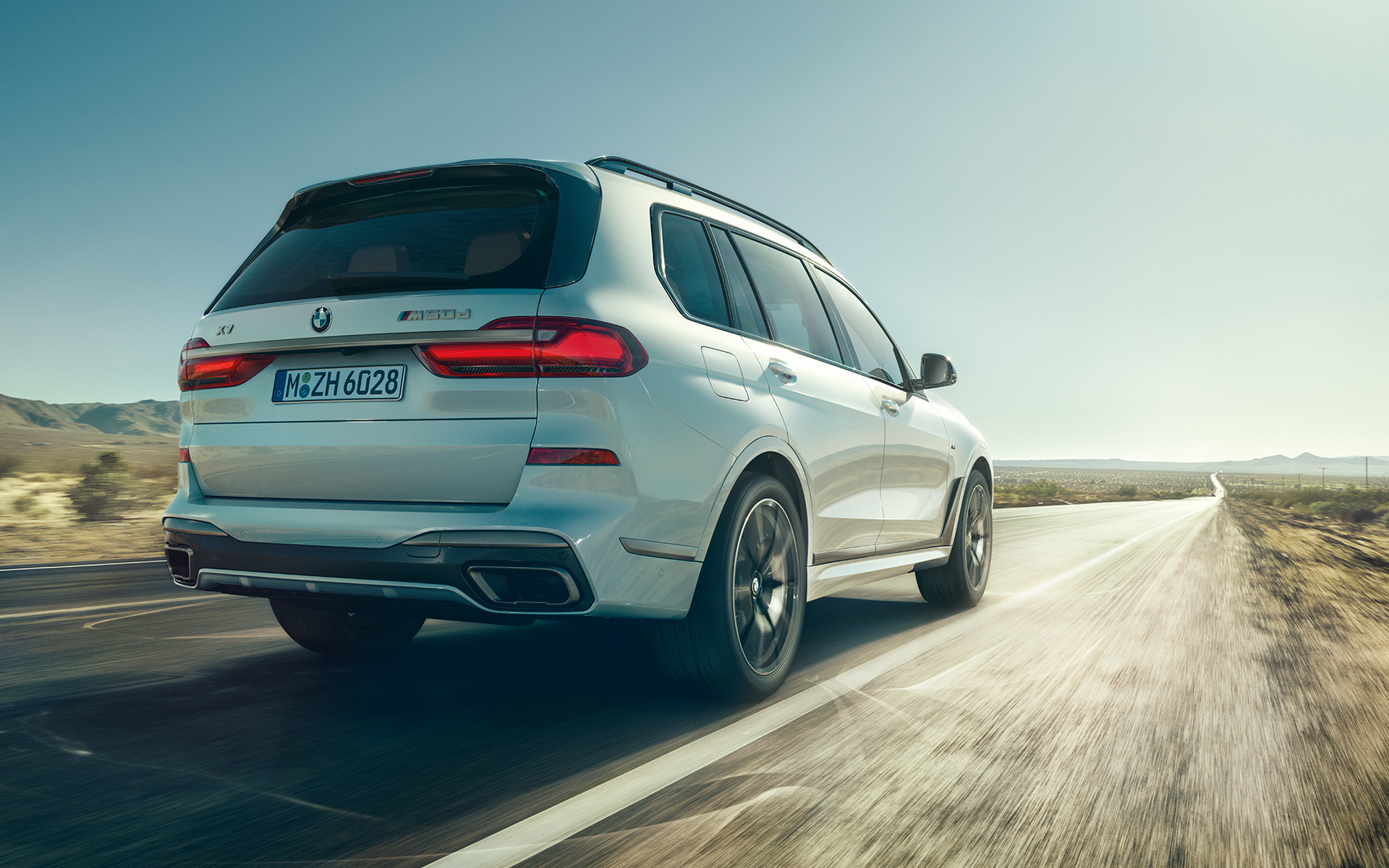 BMW X7 M50d G07 2019 Mineral White rear view driving