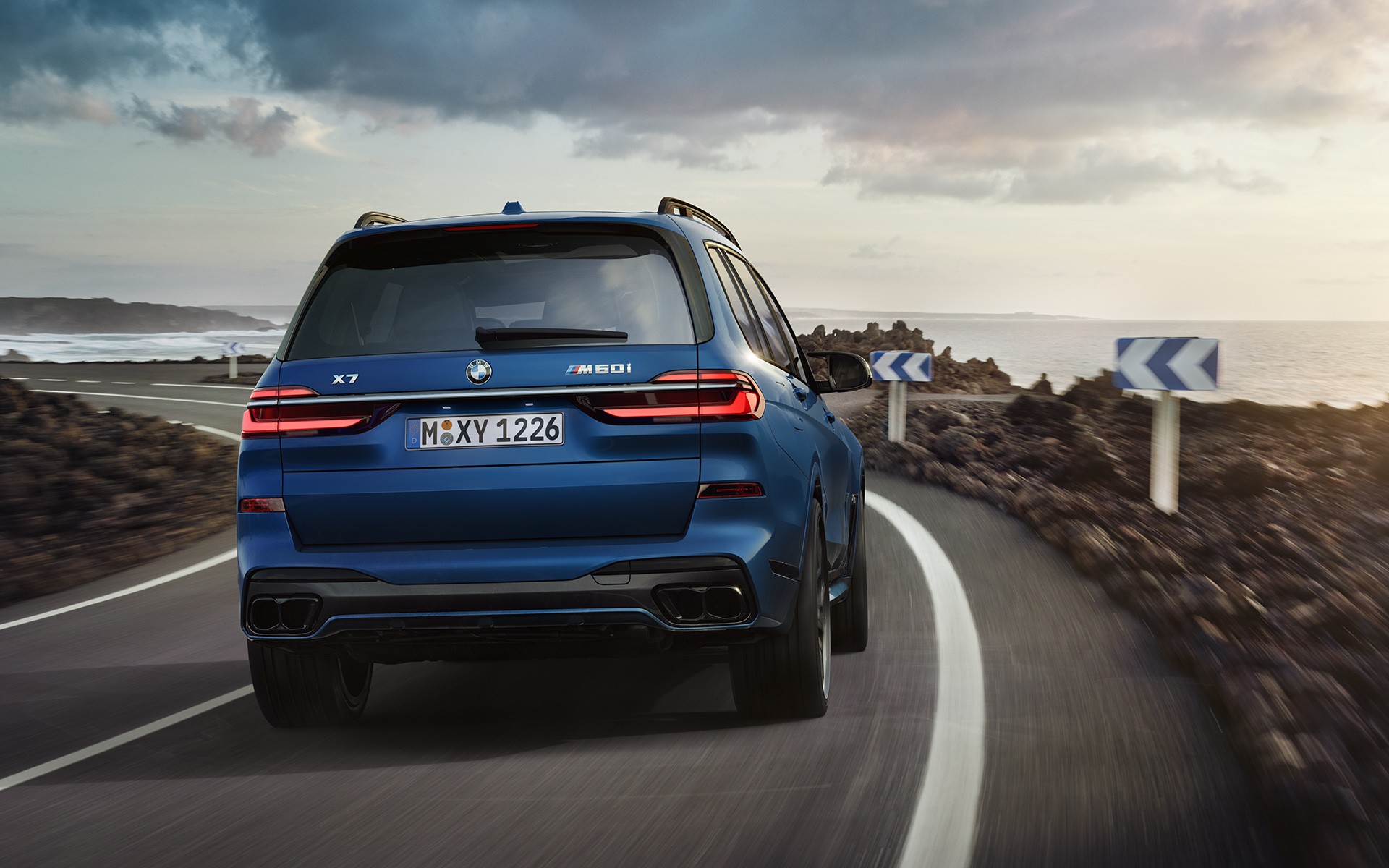BMW X7 M60i xDrive G07 LCI Frozen Marina Bay Blue rear view driving BMW X7 M60i xDrive G07 LCI Frozen Marina Bay Blue rear view driving