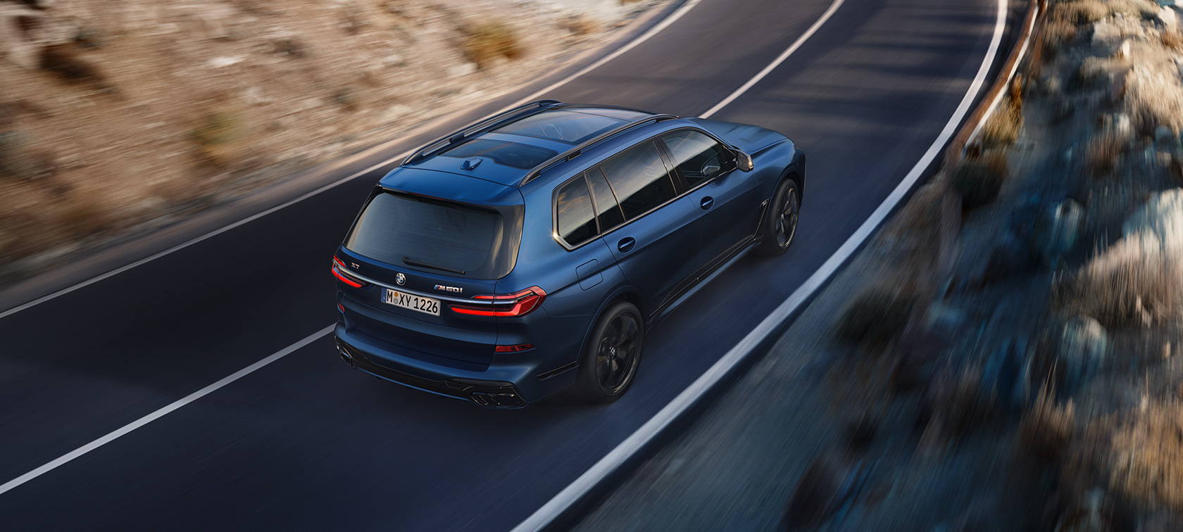 BMW X7 M60i xDrive G07 LCI Frozen Marina Bay Blue three-quarter rear view bird’s-eye view dirving BMW X7 M60i xDrive G07 LCI Frozen Marina Bay Blue three-quarter rear view bird’s-eye view dirving on the street