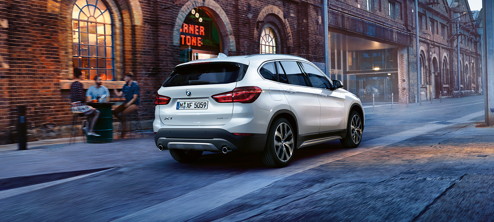 BMW X-Series X1 in metallic: rear view close to bar BMW X-Series X1 in metallic: rear view close to bar