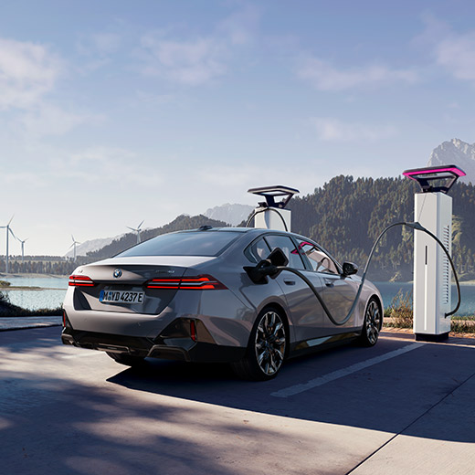 BMW i5 eDrive40 G60 at charging station in front of a lake