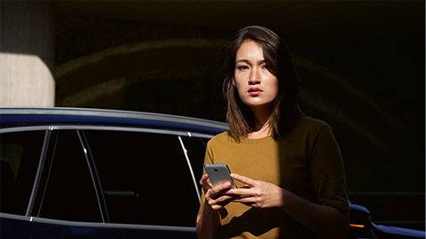 BMW ConnectedDrive digital services overview woman with smartphone in front of BMW