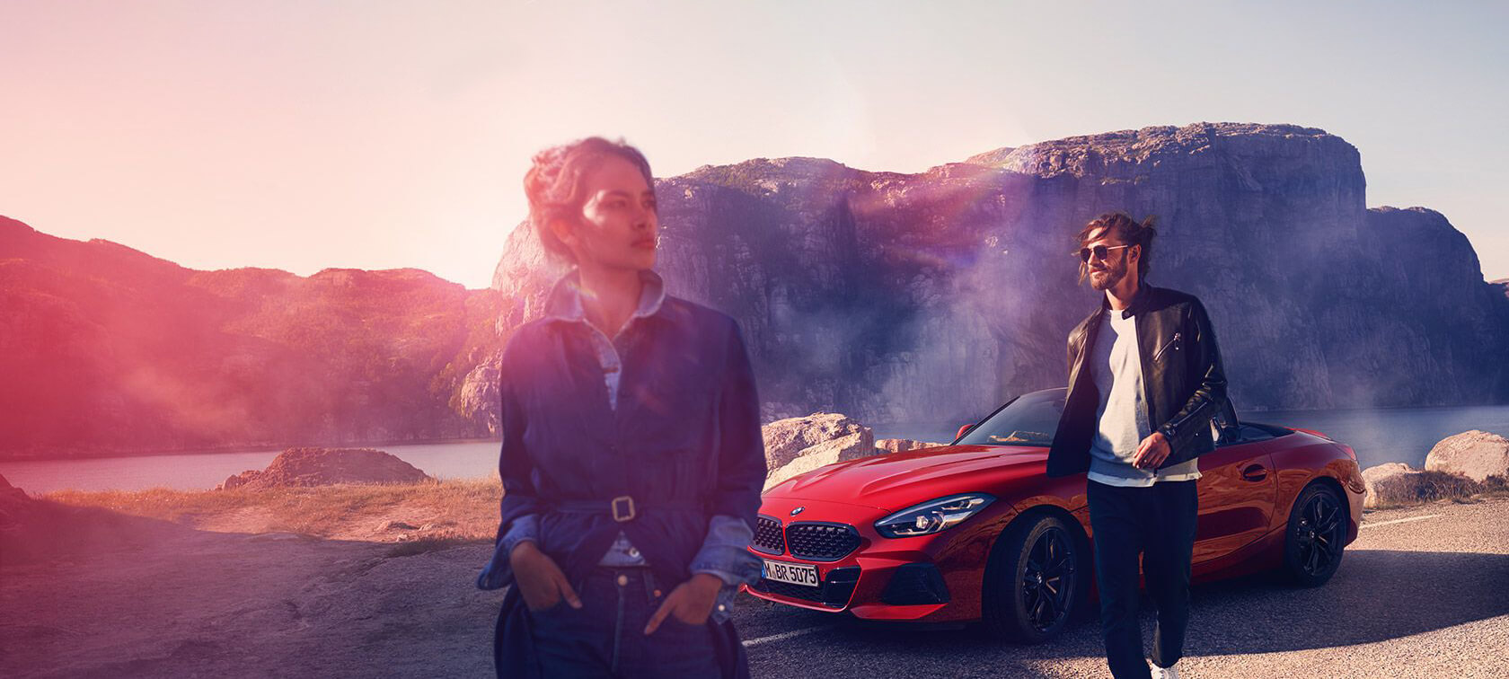 BMW three-quarter front view in front of mountain landscape with woman and man BMW Financial Services three-quarter front view in front of mountain landscape with woman and man