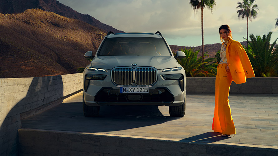 BMW Financial Services BMW three-quarter front view in front of mountain landscape with woman and man.